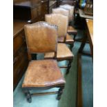 A set of four oak framed dining chairs upholstered in red leather with brass studs