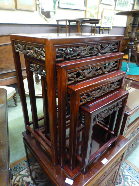 A Chinese padouk quartetto nest of tables with carved dragon frieze's