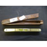 A brass spirit level in a wooden case