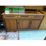 A mid-20th century teak sideboard having three doors above cupboard doors