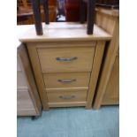 A modern oak three drawer bedside cabinet