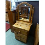 A modern pine three drawer bedside chest together with a modern pine dressing table mirror