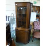 A reproduction mahogany full hight corner display cabinet having glazed top section with panel