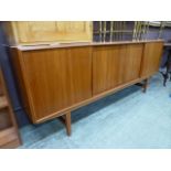 A mid 20th century teak sideboard with four sliding doors