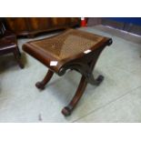 A reproduction X-framed stool with caned seat