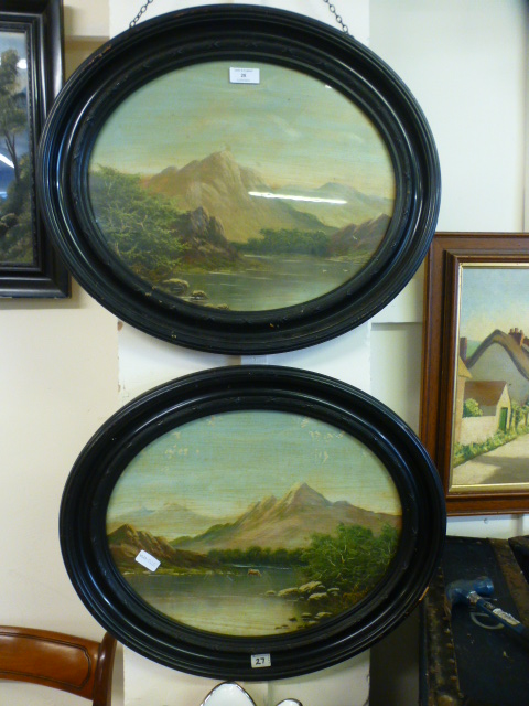 A pair of 19th century ebonised oval framed oil paintings on mountainous lake scenes