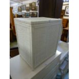 A white painted wicker linen basket