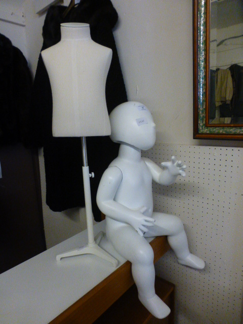 A seated child's mannequin along with a child's tailors dummy