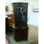 A reproduction full hight mahogany corner display cabinet having glazed door to top with door below