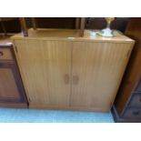 A mid-20th century teak two door stationery cabinet