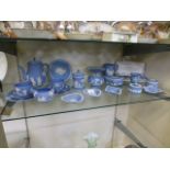 A collection of blue and white Wedgwood Jasperware trinkets to include pin dishes, mug, teapot etc.