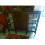 A reproduction mahogany display cabinet, two glazed doors flanking central oval panel door, l.