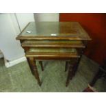 A nest of three reproduction tables with tooled leather inserts