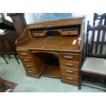 An early 20th century oak roll top desk