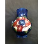 A small Moorcroft vase decorated in the Anemone pattern on a blue ground