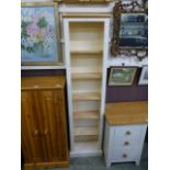 A modern full height cream painted bookcase
