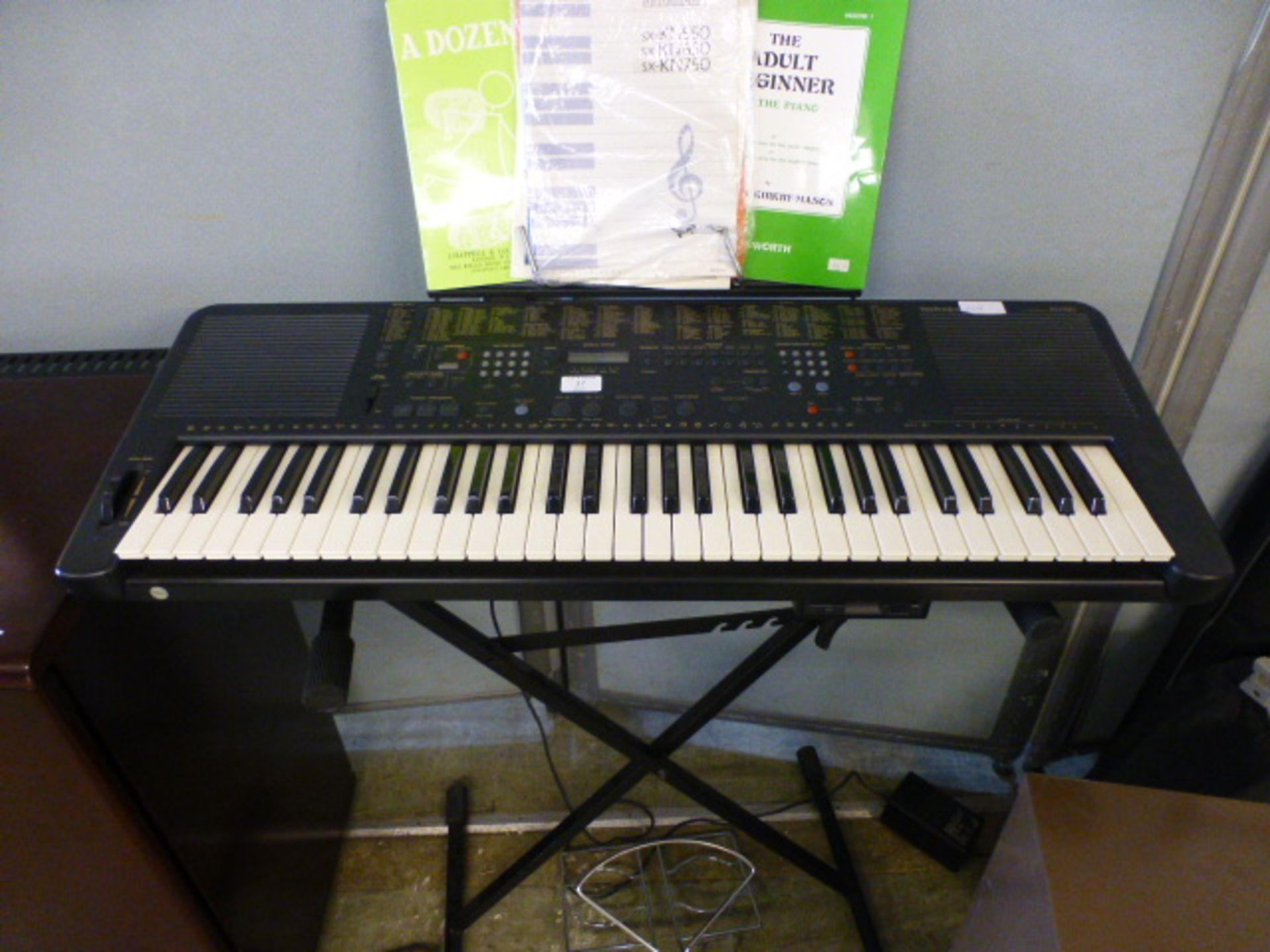 A Technics KN750 keyboard with stand and music