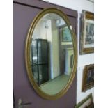An oval gilt framed bevelled glass mirror