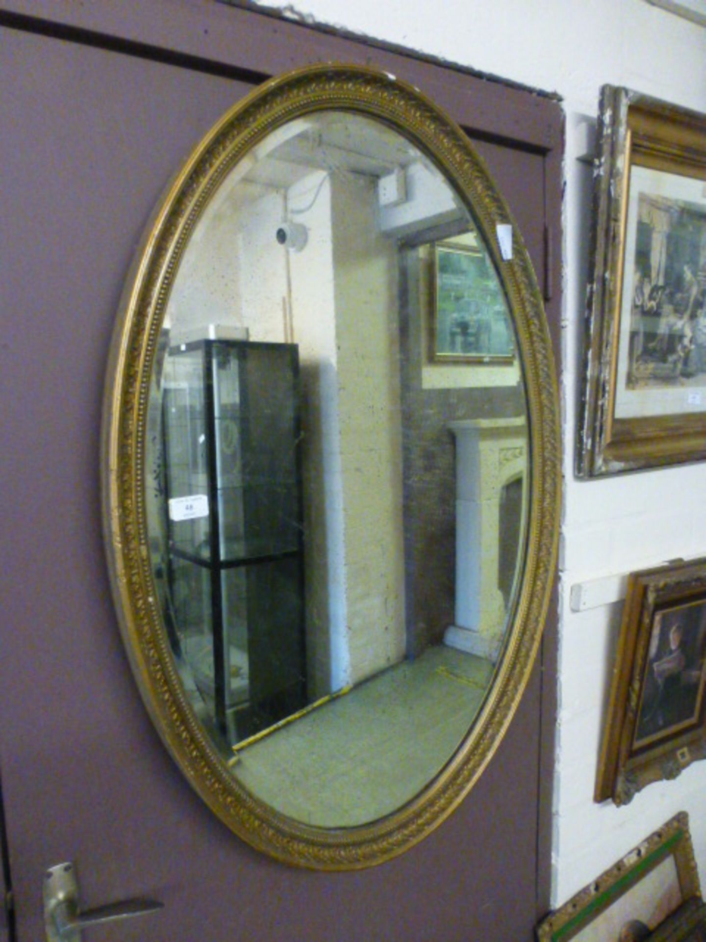 An oval gilt framed bevelled glass mirror