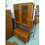 A 1970s teak unit having a raised two door glazed top section,