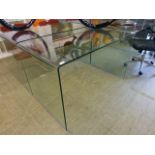 A curved glass table/desk