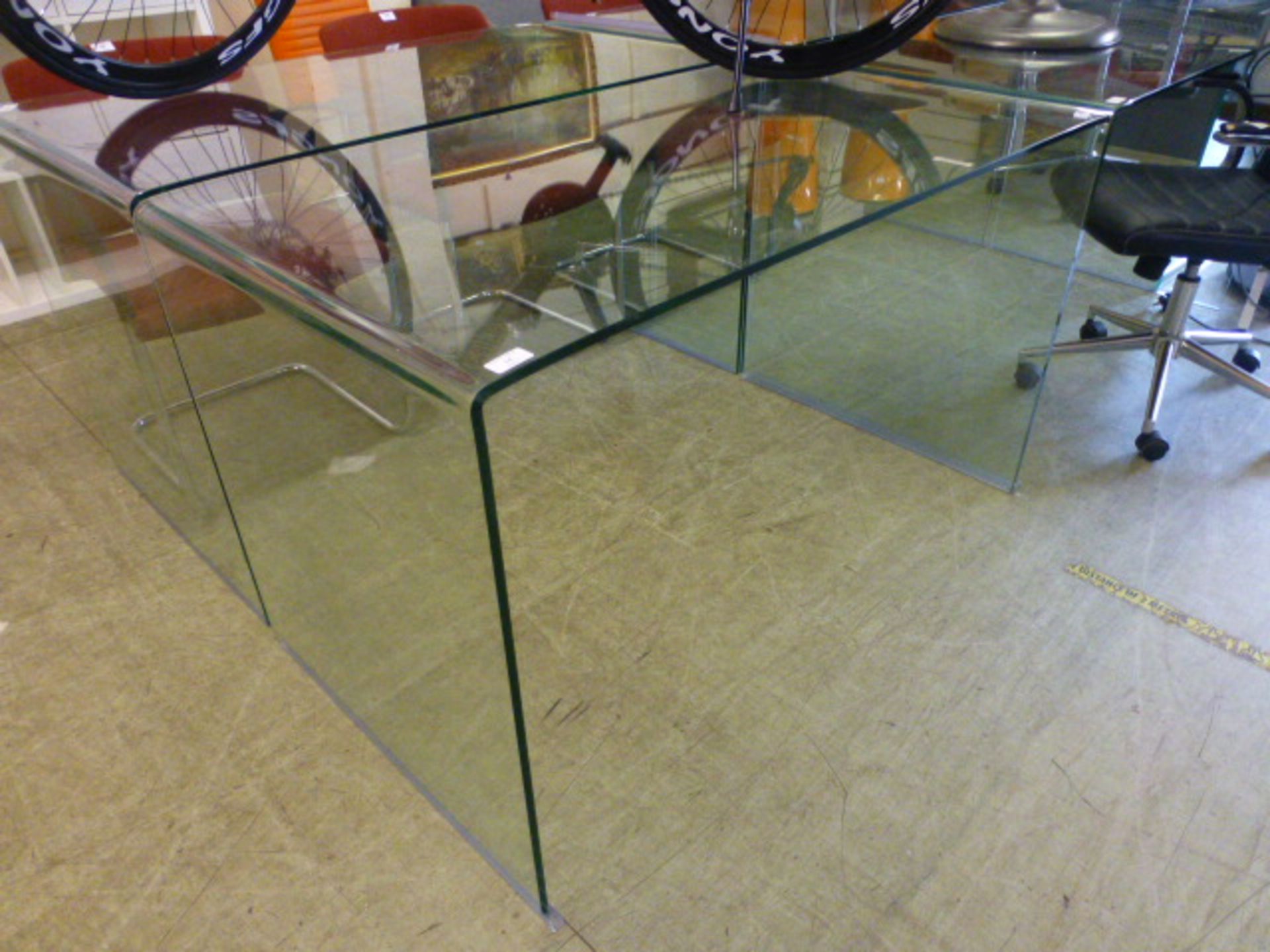 A curved glass table/desk