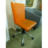 An orange leather effect office chair on five star chrome base