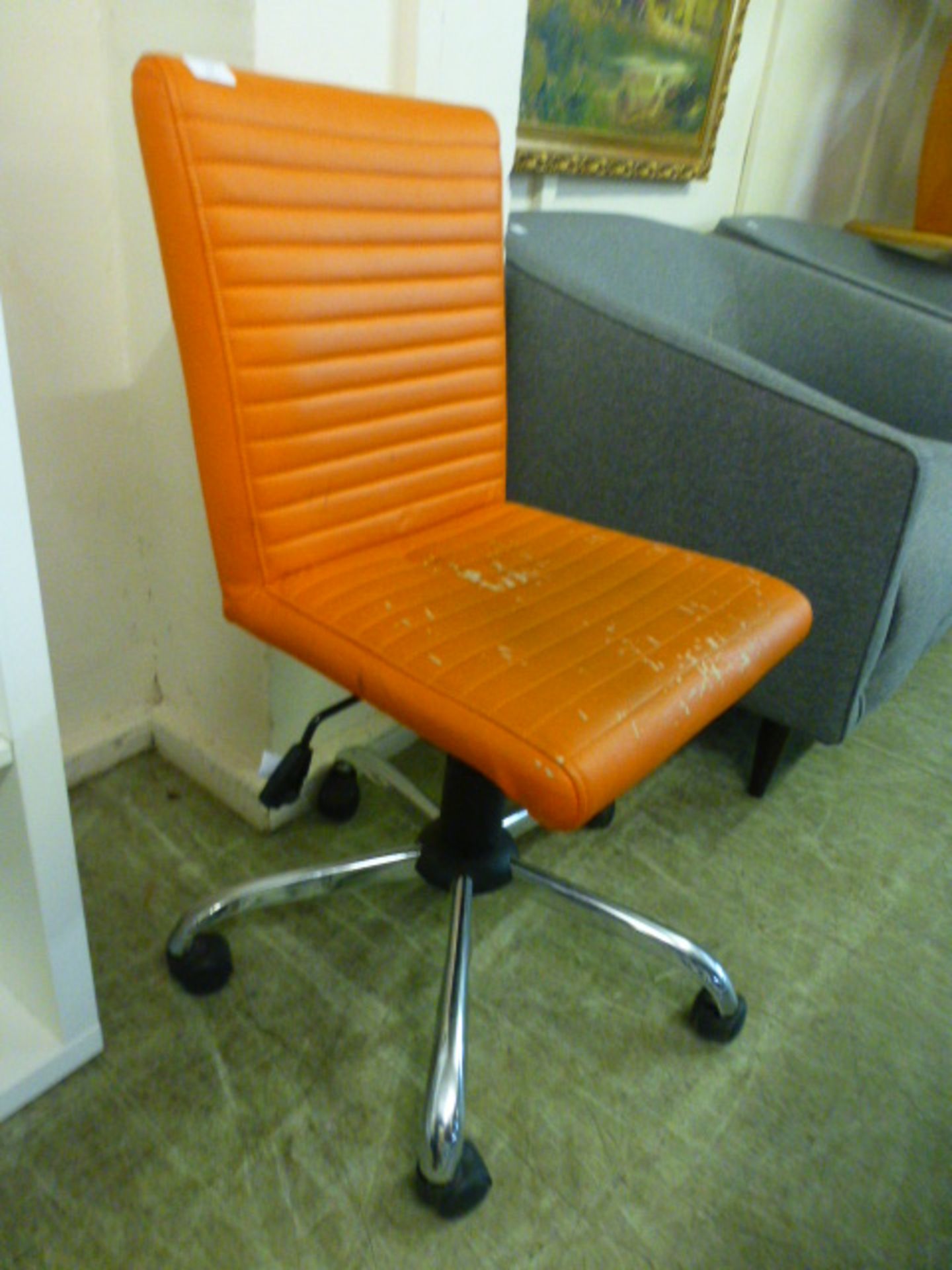 An orange leather effect office chair on five star chrome base