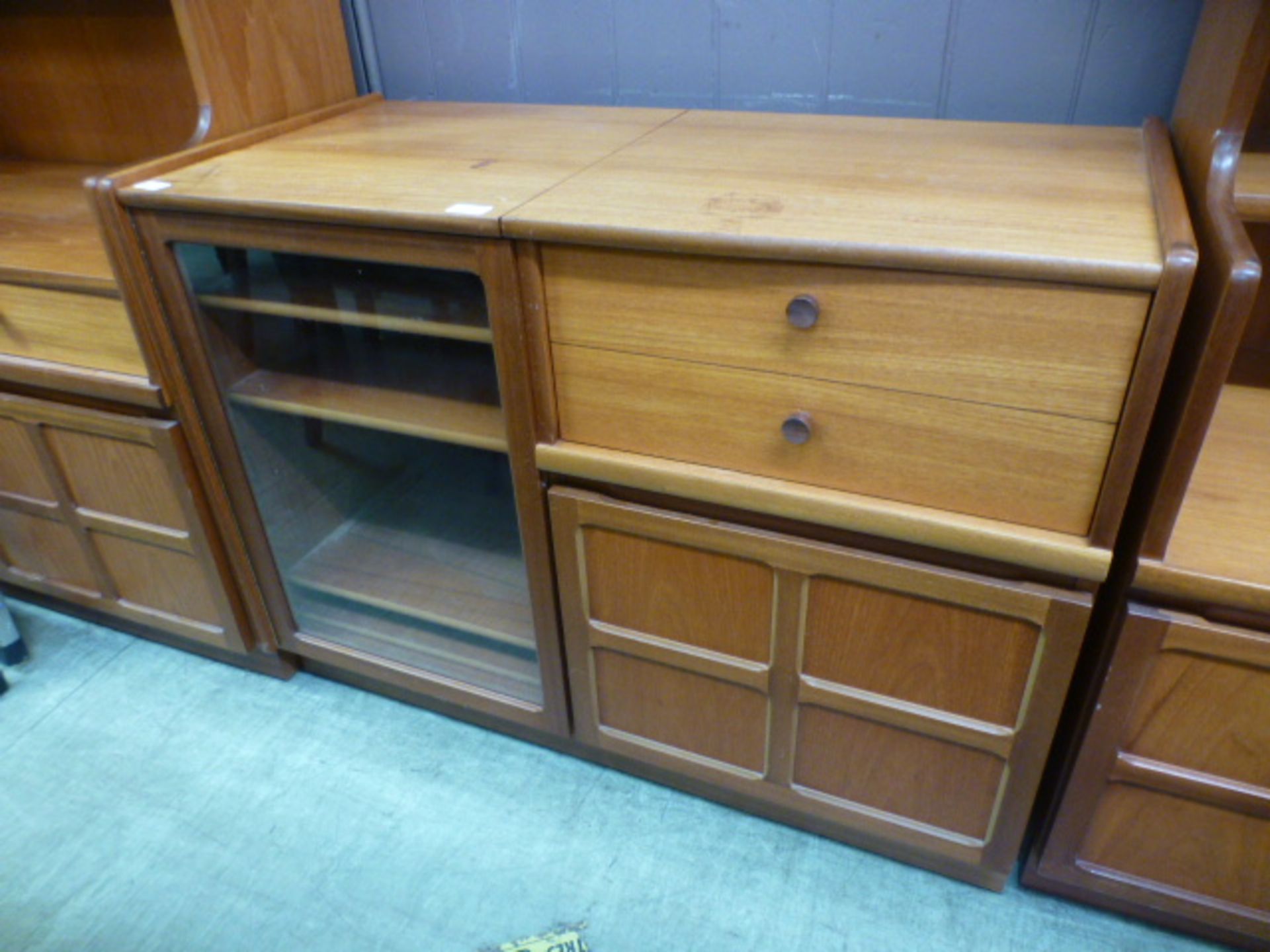 A mid-20th century design cabinet having a glazed door with drawer and cupboard by Nathan