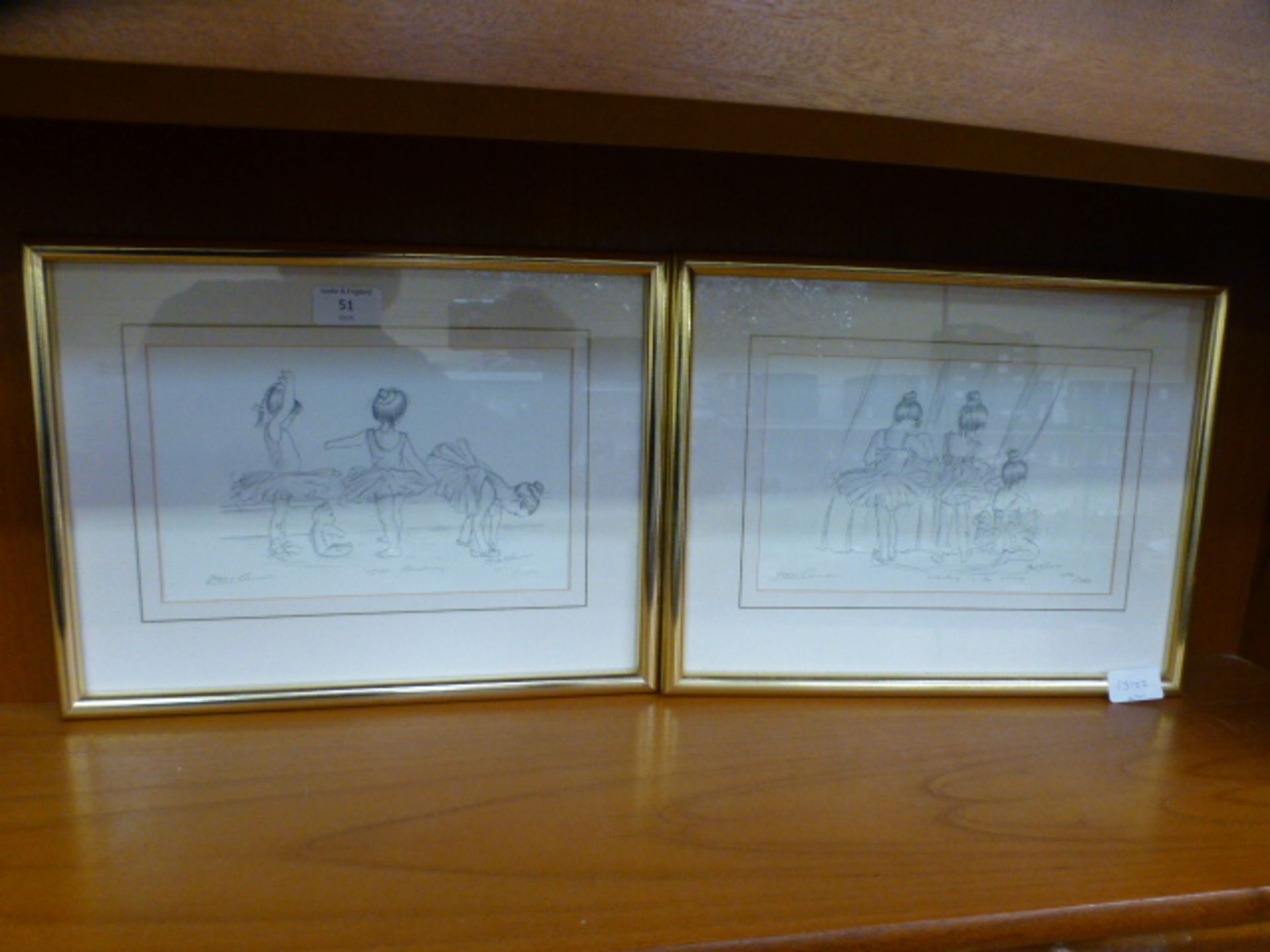 A pair of limited edition framed and glazed prints of young ballerinas (4199 of 5000) signed by