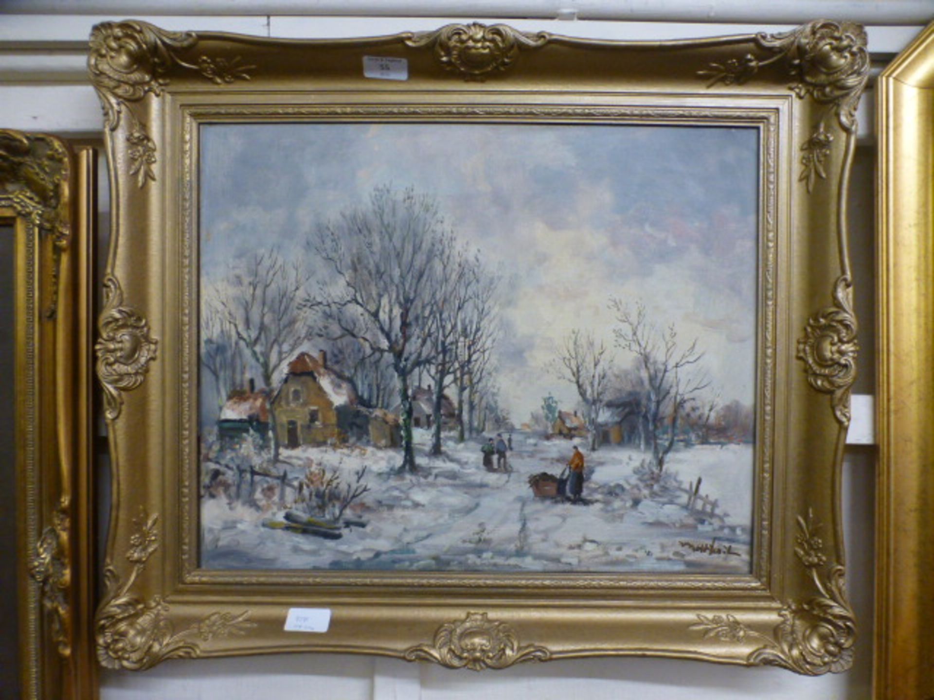 An ornate gilt framed oil on canvas of a winter village scene signed bottom right