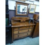 An early 20th century oak dressing chest having mirror to back on barley twist supports above