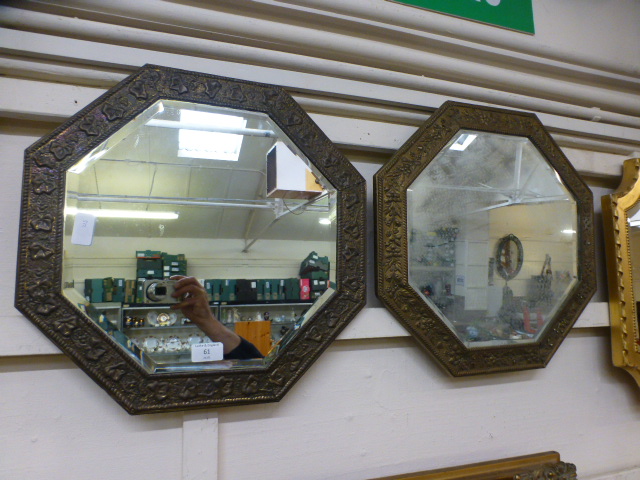 A pair of hammered brass framed bevel glass wall mirrors
