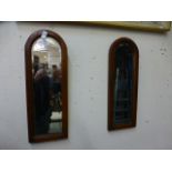 A pair of mahogany arch topped bevel glass mirrors