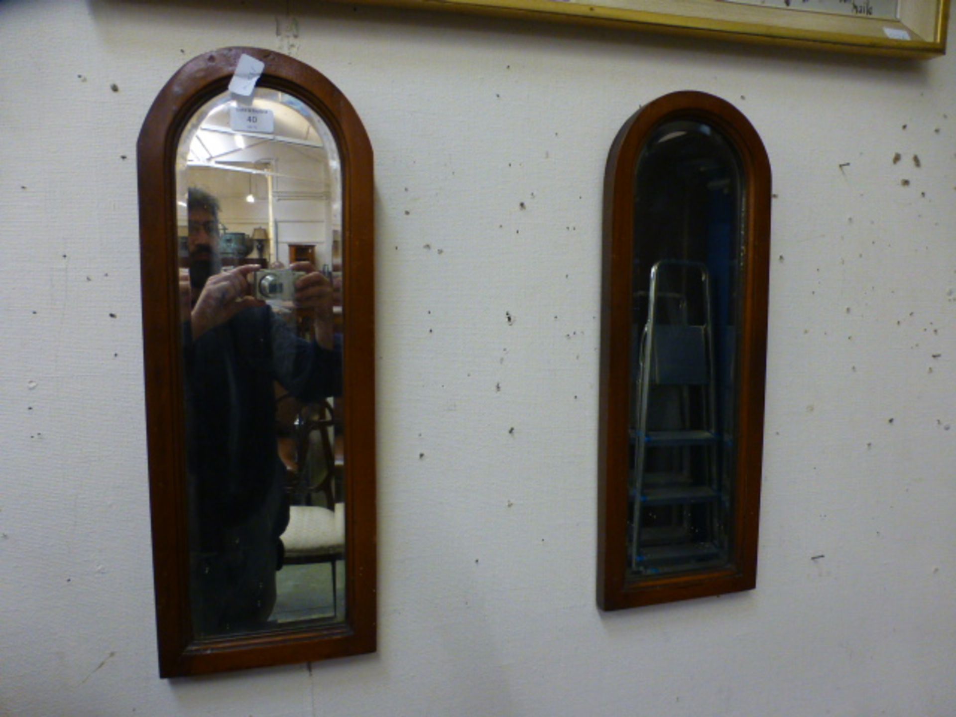 A pair of mahogany arch topped bevel glass mirrors