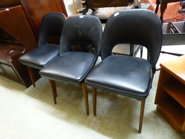 A set of three mid-20th century black Rexine upholstered dining chairs