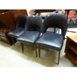 A set of three mid-20th century black Rexine upholstered dining chairs