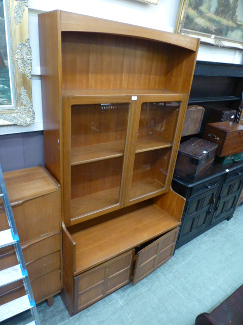 A mid-20th century teak cabinet having a pair of glazed doors above a pair of cupboard doors