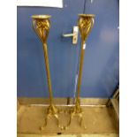 A pair of tall gilt metal candle holders