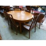 A mid-20th century teak extending dining table together with a set of four standard and two carver