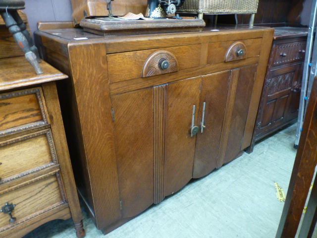 An early 20th century oak veneered sideboard having two drawers above cupboard doors