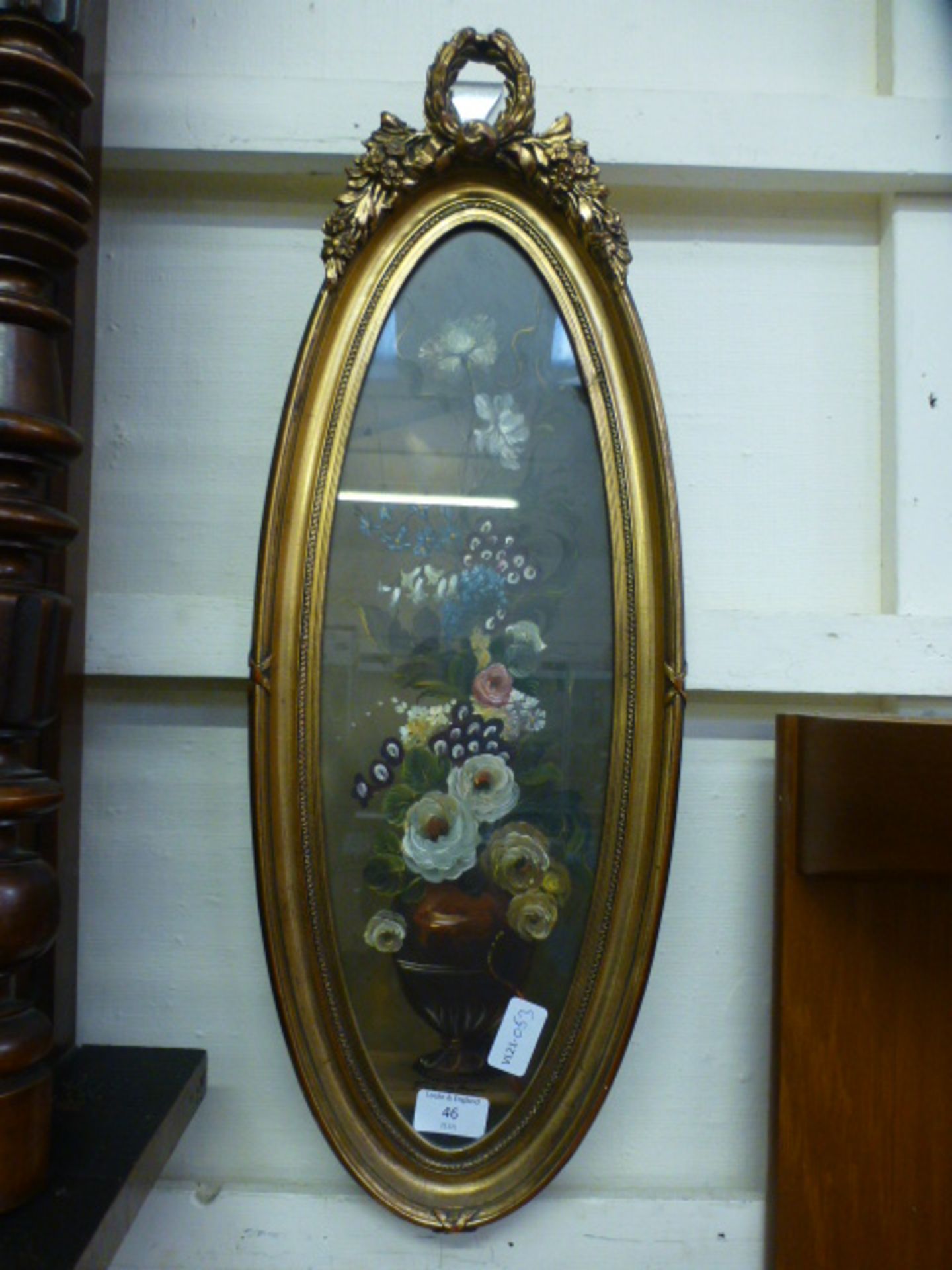 An ornate gilt oval framed and glazed oil of still life signed at bottom