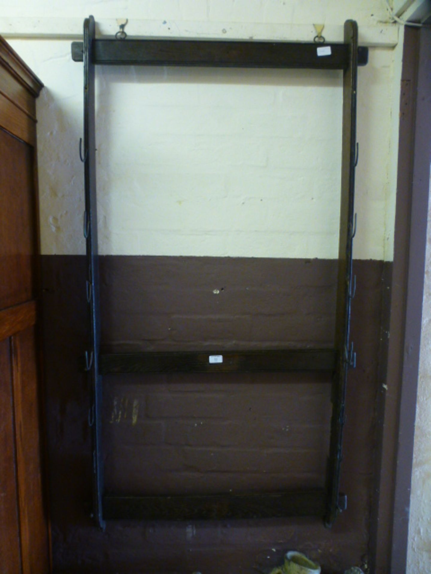 An 18th century oak wall mounted open rack with hooks