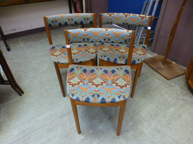 Three mid-20th century teak dining chairs upholstered in a Liberty design fabric