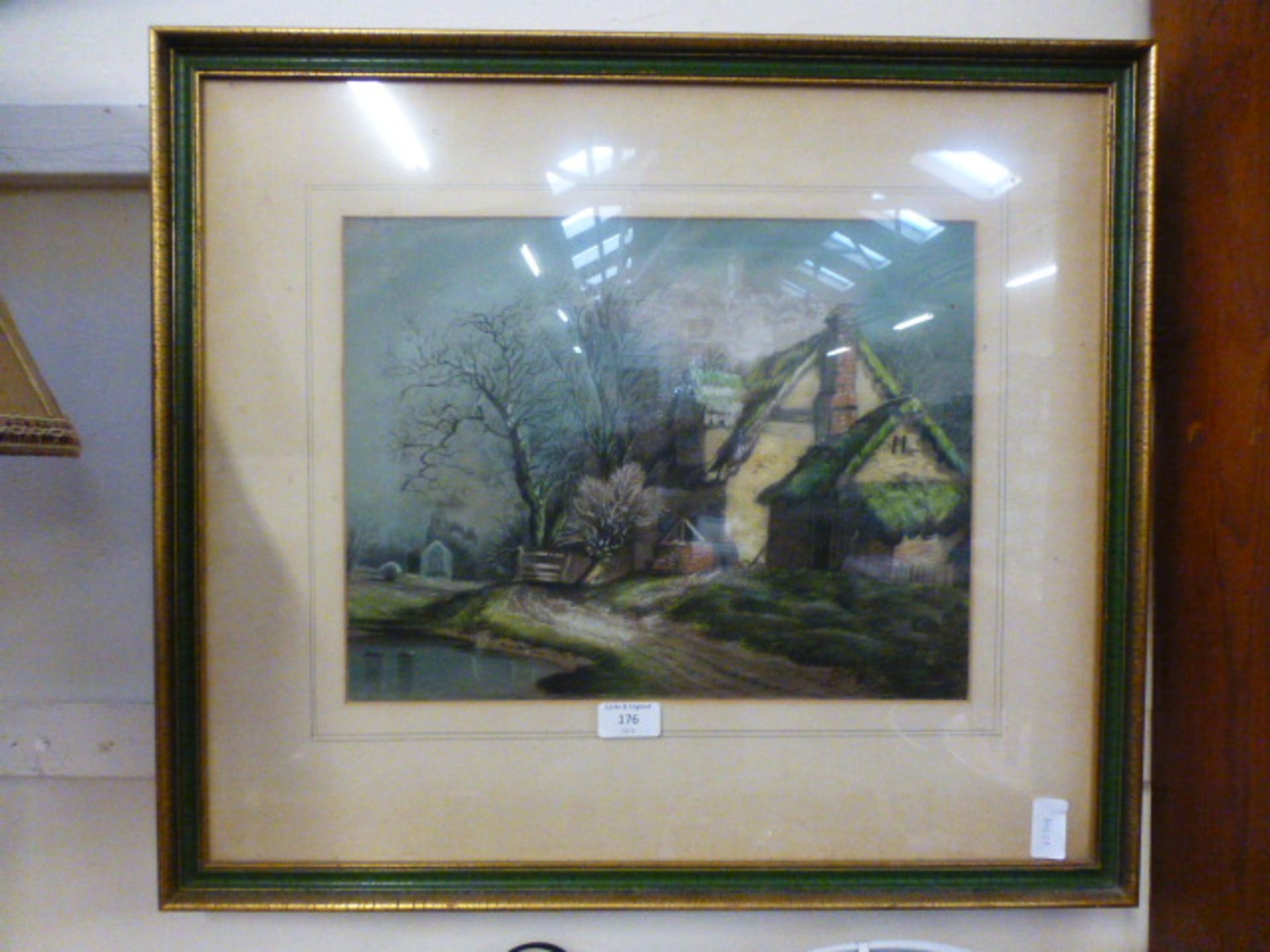 A framed and glazed pastel of church and cottage scene by pond
