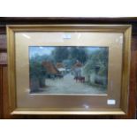 A gilt framed and glazed water colour of cattle in village scene signed bottom right A H 1909