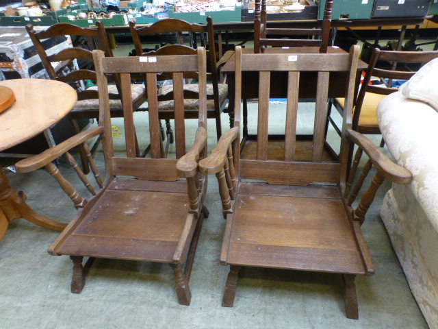 A pair of early 20th century oak open armchairs