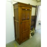 An early 20th century linen fold oak hall cupboard