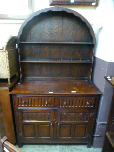 An early 20th century oak Dutch dresser having arch top plate rack,