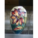 A Moorcroft vase decorated in the Clematis pattern on a wood smoke ground
